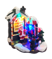 Tradineur - Ciudad de Navidad con iluminación LED - Fabricado en resina - casita de navidad nevada con figuras a pilas - 10,5 x 11,5 x 6,5 cm